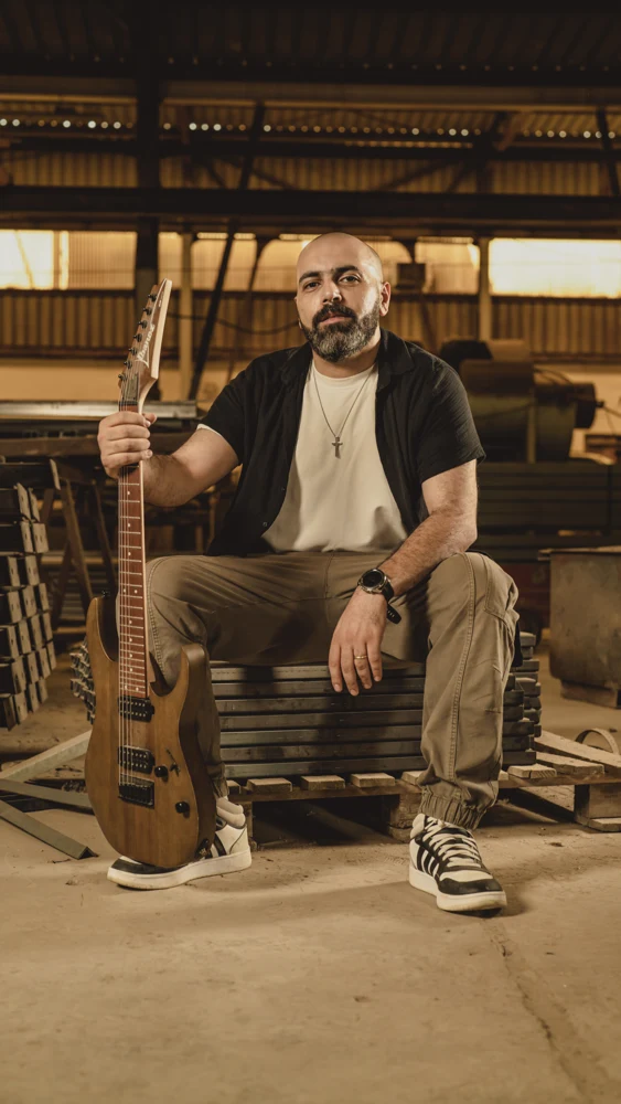 Bishoy Assem seated with his guitar