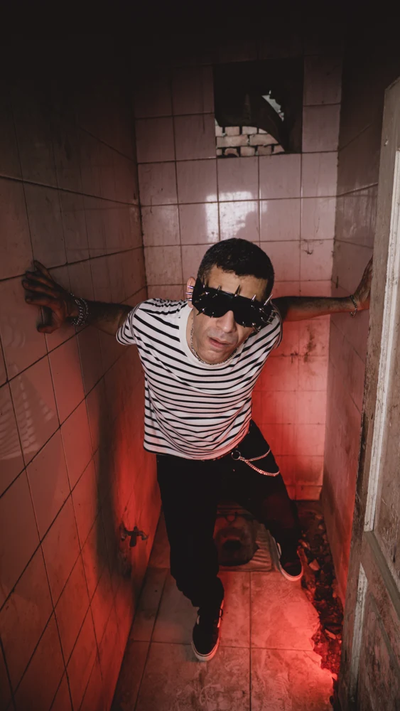 Omar Kamel photoshoot portrait in a red-lit stairwell